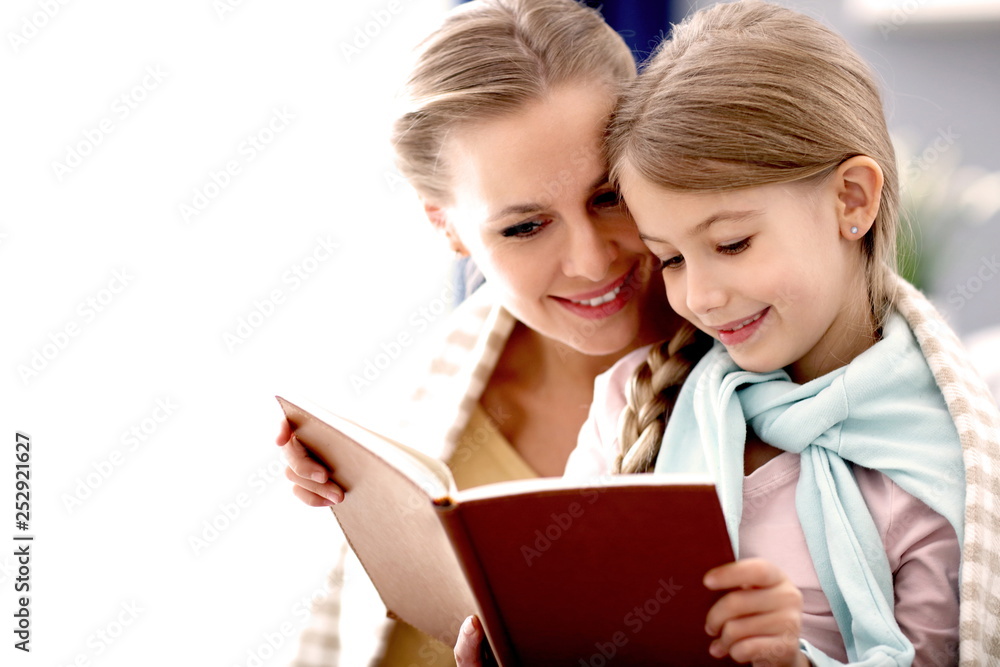 Beautiful mom and her daughter reading at home Beautiful mom and her daughter reading at home