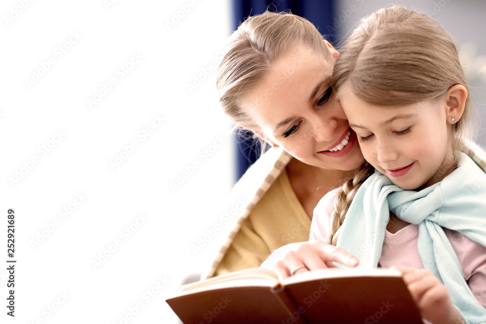 Beautiful mom and her daughter reading at home Beautiful mom and her daughter reading at home