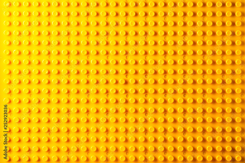 Yellow plastic construction plate.Plastic construction block pattern Yellow plastic construction plate.Plastic construction block pattern