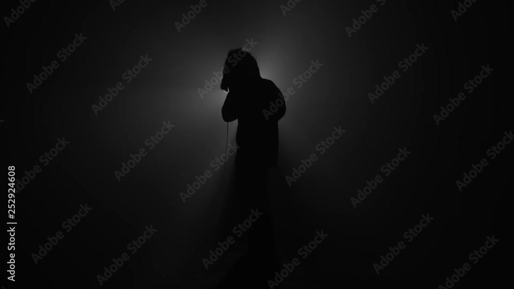Silhouette of rapper performing with microphone Silhouette of rapper performing with microphone
