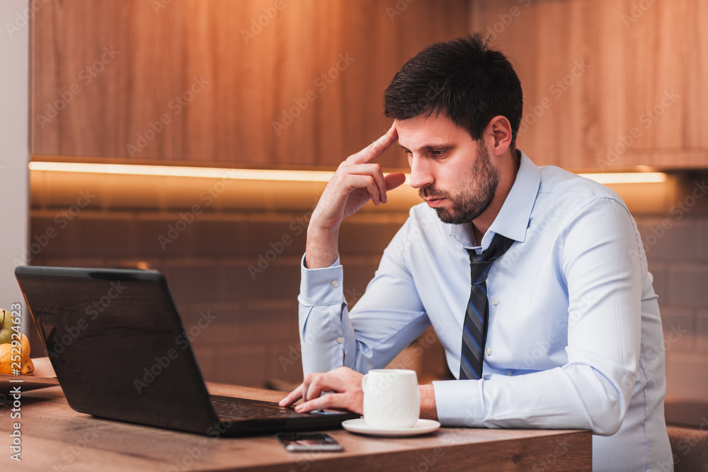 Young businessman working on laptop at home Young businessman working on laptop at home