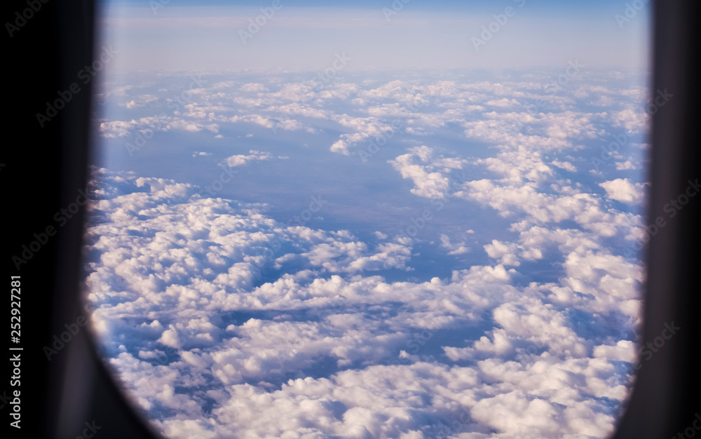 View from a window of the passenger plane on the sky and the earth from height. Beautiful view from air. Clouds and blue sky. View from a window of the passenger plane on the sky and the earth from height. Beautiful view from air. Clouds and blue sky.