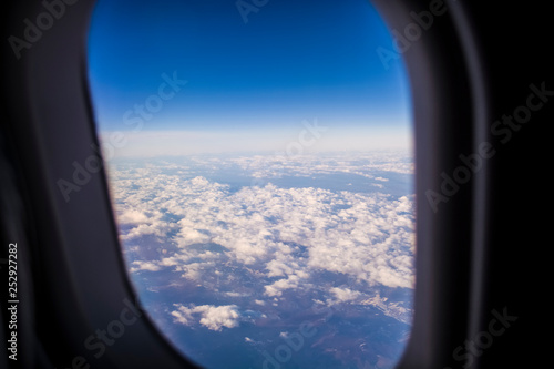 View from a window of the passenger plane on the sky and the earth from height. Beautiful view from air. Clouds and blue sky.