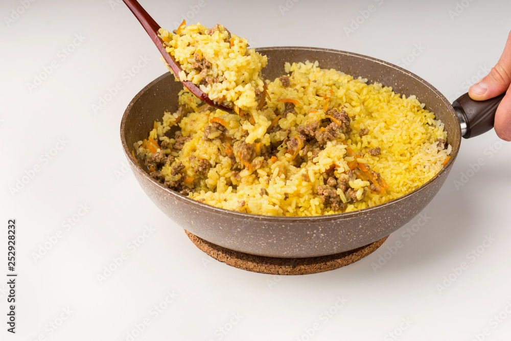 Frying pan full of yellow rice minced meat on white Frying pan full of yellow rice minced meat on white