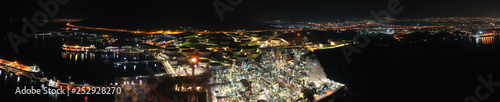 Aerial drone night shot of industrial oil refinery plant with dazzling lights
