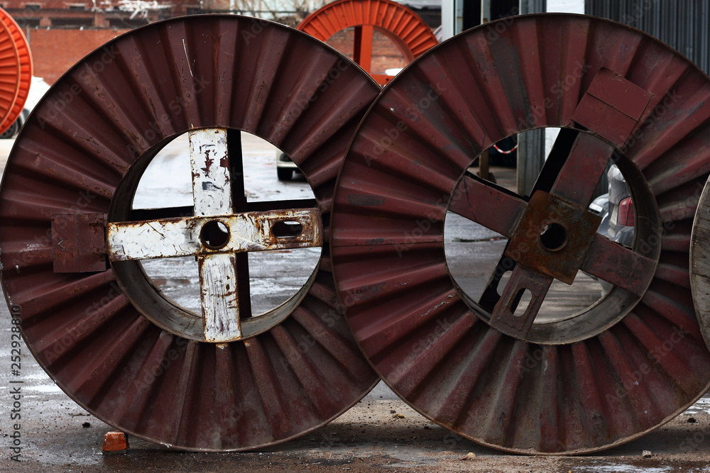 Wooden and metal industrial cable reels in the factory outside