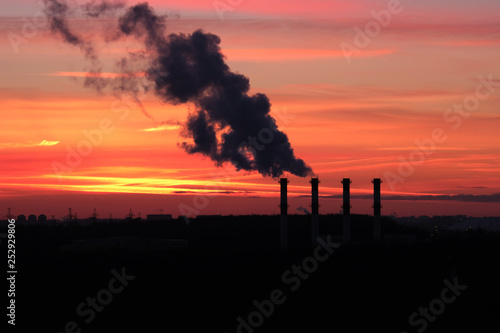 concept environmental pollution. smoke from the pipes against the backdrop of a beautiful sunset