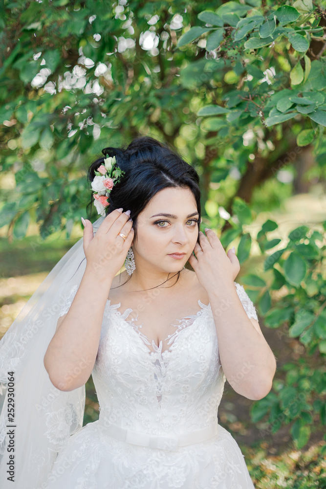 fashion photo of beautiful bride with dark hair in elegant wedding dress and diadem posing in room in the wedding morning. fashion photo of beautiful bride with dark hair in elegant wedding dress and diadem posing in room in the wedding morning.