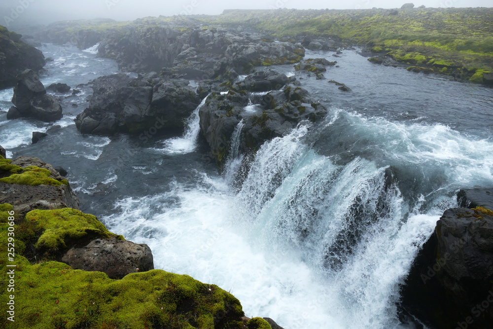 Fototapeta premium Icy blue waterfall on waterfall trail, stage one of Fimmvörduhals mountain pass, Iceland