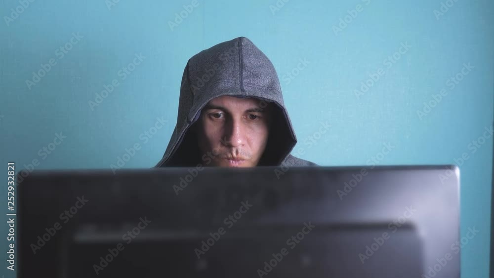 man hacker in the hood hacking lifestyle network concept. unknown hacker criminal breaks into computer protection on the Internet passwords. male hacker penetrates into hack network protection web man hacker in the hood hacking lifestyle network concept. unknown hacker criminal breaks into computer protection on the Internet passwords. male hacker penetrates into hack network protection web