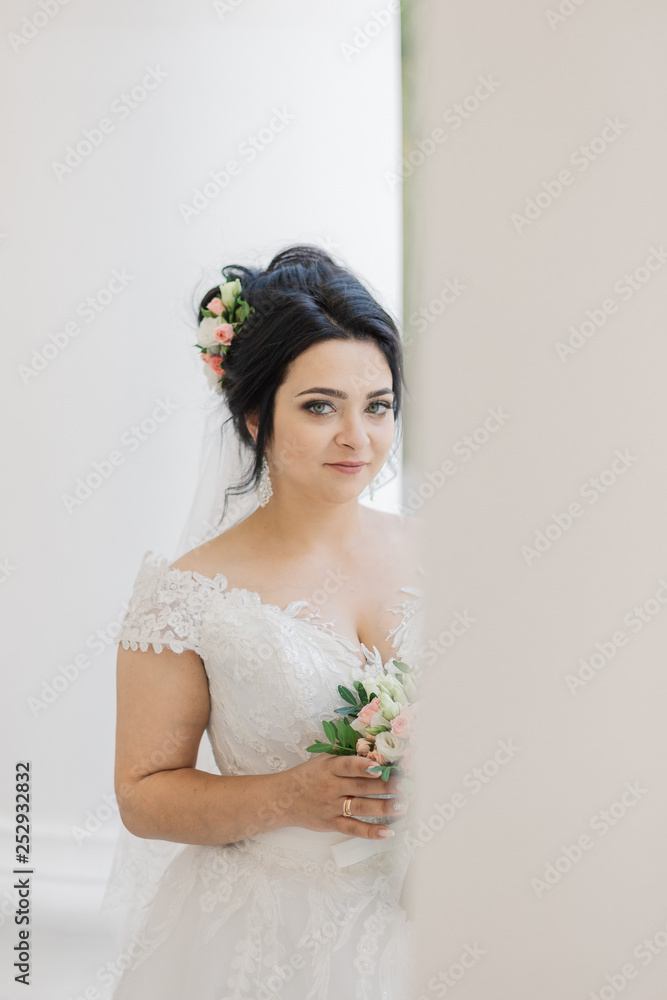 Very beautiful bride is holding a bouquet.