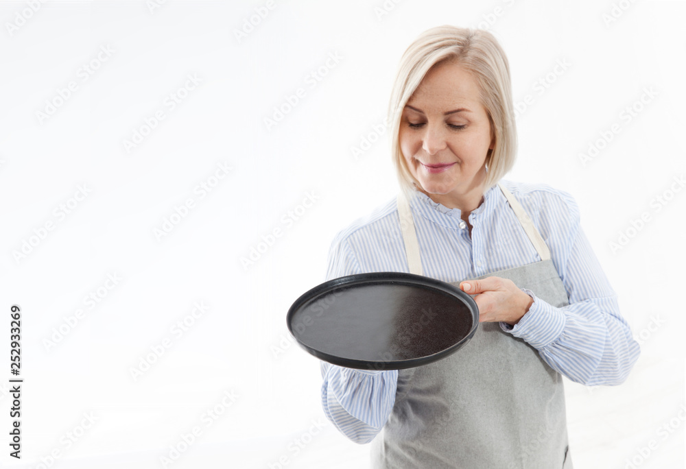 Kitchen woman gives empty black plate for your advertising products isolated on white background. Mock up for use Kitchen woman gives empty black plate for your advertising products isolated on white background. Mock up for use
