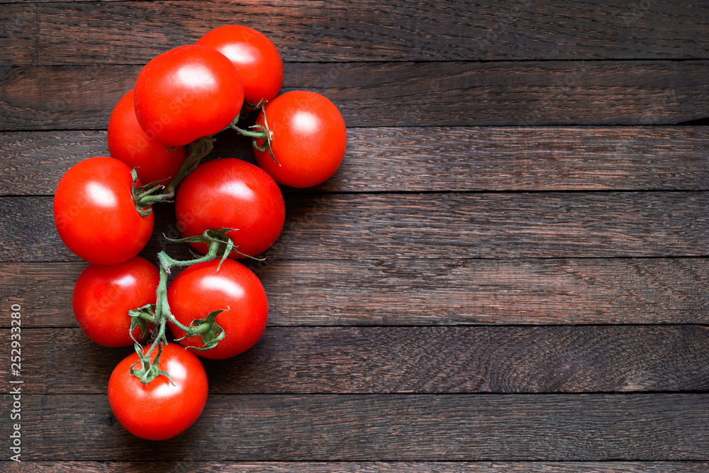 Tomatoes on dark wooden table with copy space Tomatoes on dark wooden table with copy space