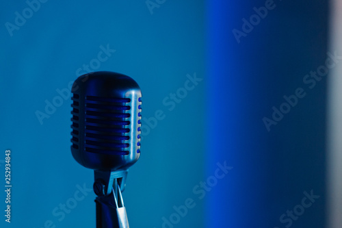 Retro microphone against dim blue light restaurant background.