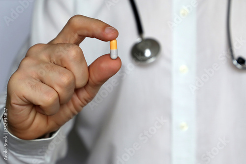 Doctor with pill, man giving medication in capsule. Concept of medical exam, dose of drugs, vitamins, medical prescription, pharmacy