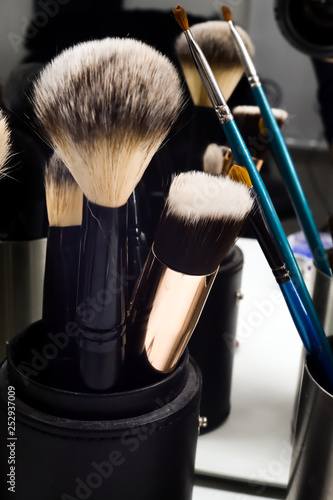 many make up brushes in metal black can on table in beauty salon close up