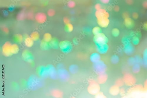 Pale green abstract background with colorful blots in blur.