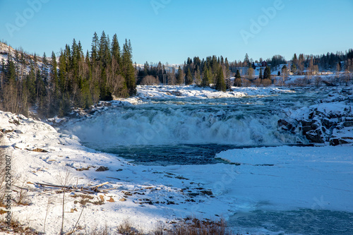 The salmon waterfall in Wefsna river on a cold winter day, in Northern NorwayIcy running water Laksforsen Norway photo