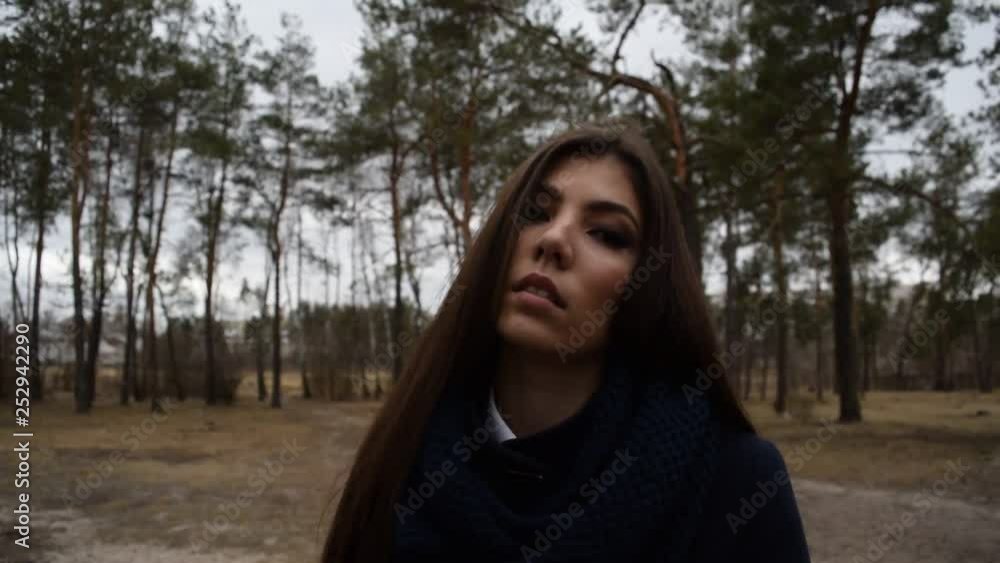 Fashion portrait of a young cheerful girl in a coat in a pine forest. Fashion portrait of a young cheerful girl in a coat in a pine forest.