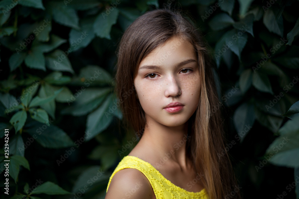 Girl in a yellow dress with a bouquet of flowers on the background of ivy. Portrait of Ukrainian Girl in a yellow dress with a bouquet of flowers on the background of ivy. Portrait of Ukrainian