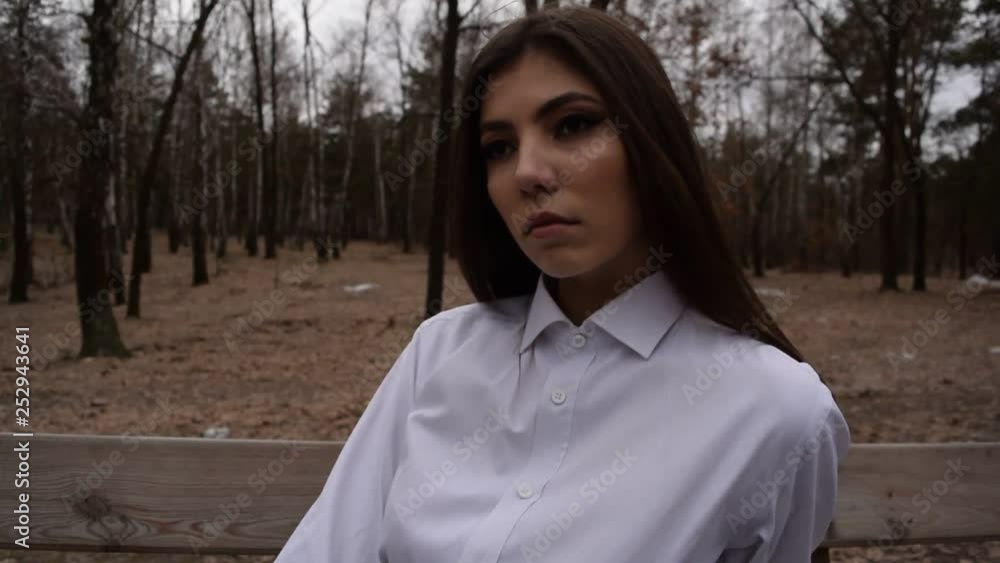 Portrait of a young brunette girl in a white shirt in a dark forest. Portrait of a young brunette girl in a white shirt in a dark forest.