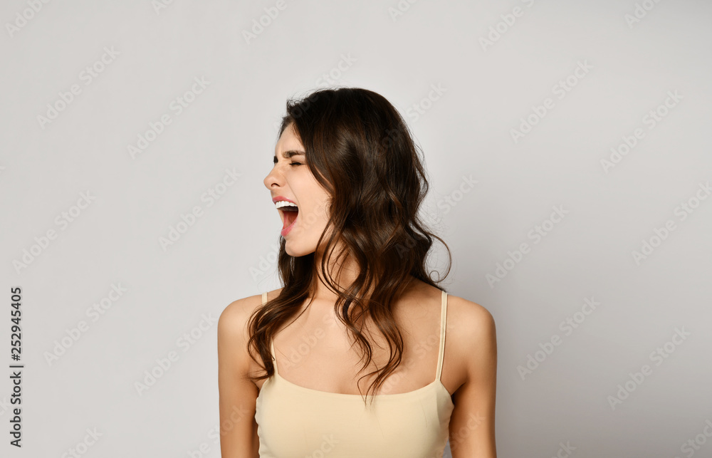 Young beautiful woman has turned her head to the side and shouts or yell Young beautiful woman has turned her head to the side and shouts or yell