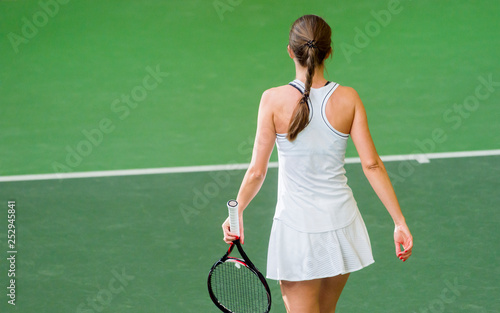 back view of a female tennis player with a racket in action © Augustas Cetkauskas