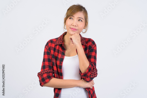 Portrait of young beautiful Asian hipster woman thinking