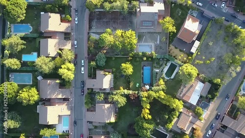 Aerial footage view from the drone of a neighborhood with its swimming pools inside a forest in the outskirts of Madrid city seeing the urban planning of the area with its home and streets aligned