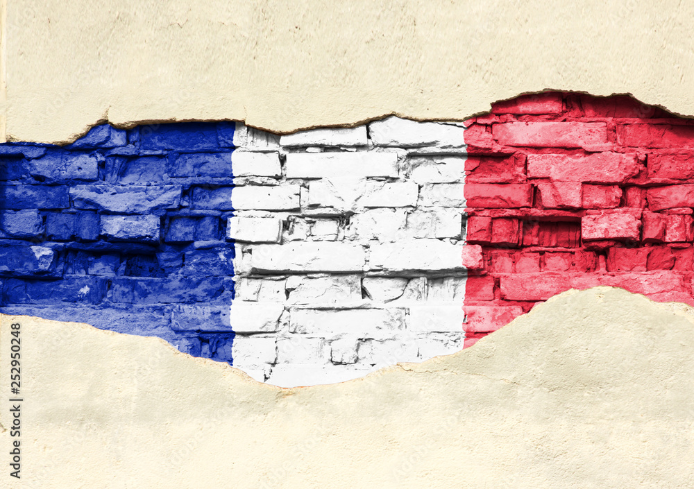 National flag of France on a brick background. Brick wall with partially destroyed plaster, background or texture.