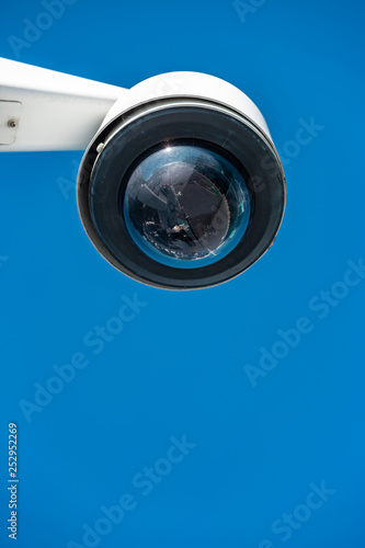 Modern CCTV camera on a clear blue sky background