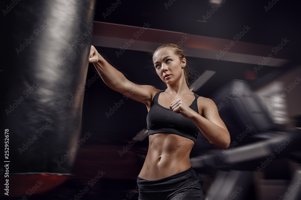 Young female boxer preparing to punch bag. concept of will win, power of spirit