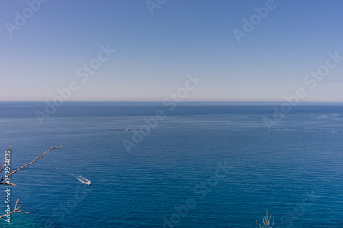 Italy, Cinque Terre, Corniglia, a small boat in a large body of water © SkandaRamana