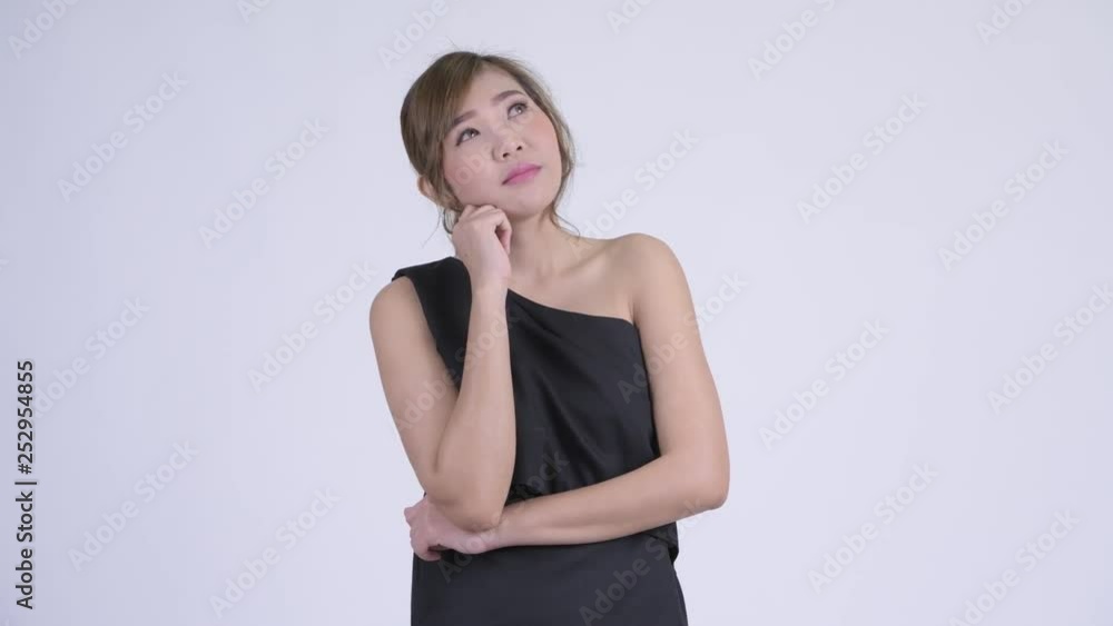 Happy young beautiful Asian woman thinking and looking up Happy young beautiful Asian woman thinking and looking up