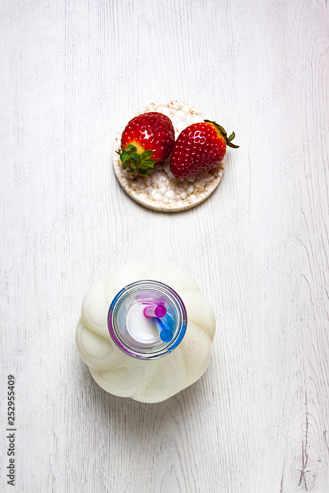 VISTA CENITAL DE BOTELLA DE LECHE Y FRESAS SOBRE TORTA DE ARROZ VISTA CENITAL DE BOTELLA DE LECHE Y FRESAS SOBRE TORTA DE ARROZ
