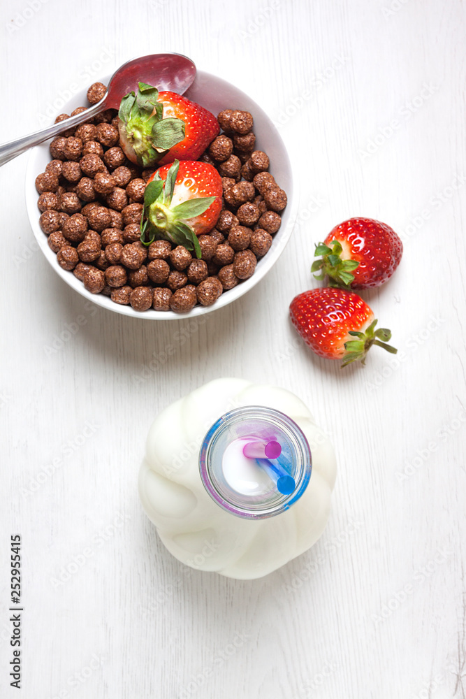 VISTA CENITAL DE DESAYUNO CON FRESAS ROJAS Y CEREALES DE CHOCOLATE Y BOTELLA DE LECHE VISTA CENITAL DE DESAYUNO CON FRESAS ROJAS Y CEREALES DE CHOCOLATE Y BOTELLA DE LECHE