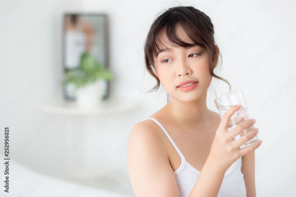 Beautiful portrait young asian woman smile and drinking water glass with fresh and pure for diet, beauty girl thirsty and charming holding beverage with healthy in the bedroom, health care concept. Beautiful portrait young asian woman smile and drinking water glass with fresh and pure for diet, beauty girl thirsty and charming holding beverage with healthy in the bedroom, health care concept.