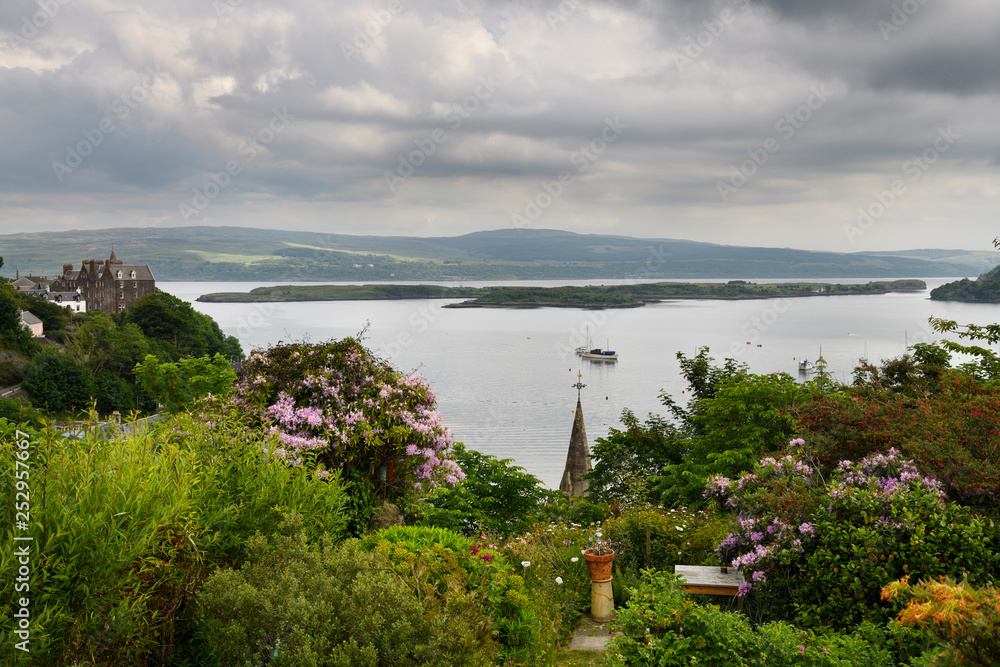 Hilltop garden view of Tobermory harbour on Isle of Mull with Calve Island in the Sound of Mull Inner Hebrides Scotland UK