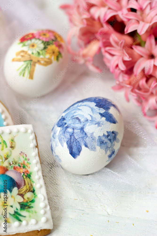 Decorated Easter eggs and flowers on white tulle background; decoupage technique Decorated Easter eggs and flowers on white tulle background; decoupage technique