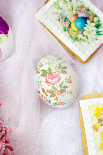 Decorated Easter eggs and flowers on white tulle background; decoupage technique