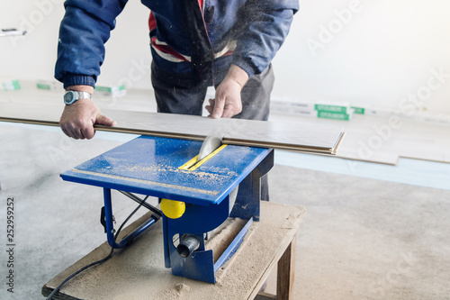 Professional Worker Using Circular Saw Cutting of New Laminate Flooring Renovation