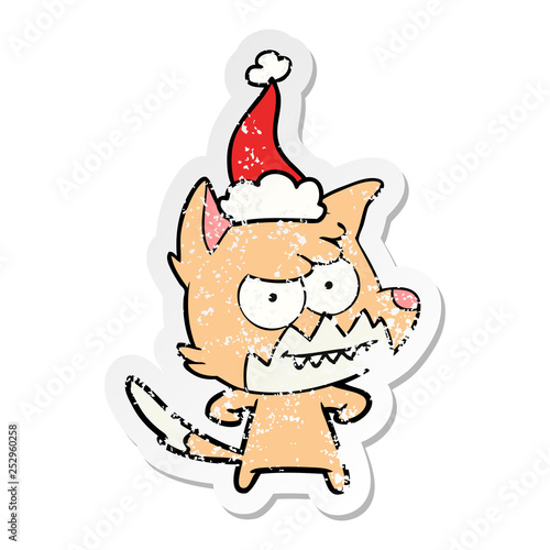 distressed sticker cartoon of a grinning fox wearing santa hat