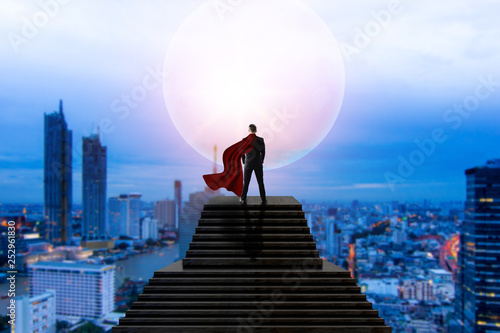 super hero business man in suit standing and looking on cityscape view and thinking business plan of the future