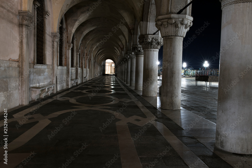 Row of arches underneath the Doge's Palace in Piazza San Marco in Venice. Archway, corridor and medieval columns in Venice