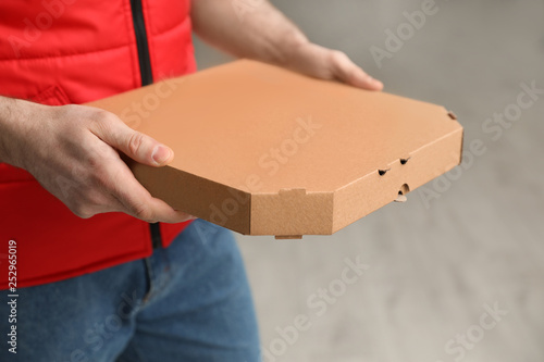 Man with pizza box indoors, closeup. Food delivery service © New Africa
