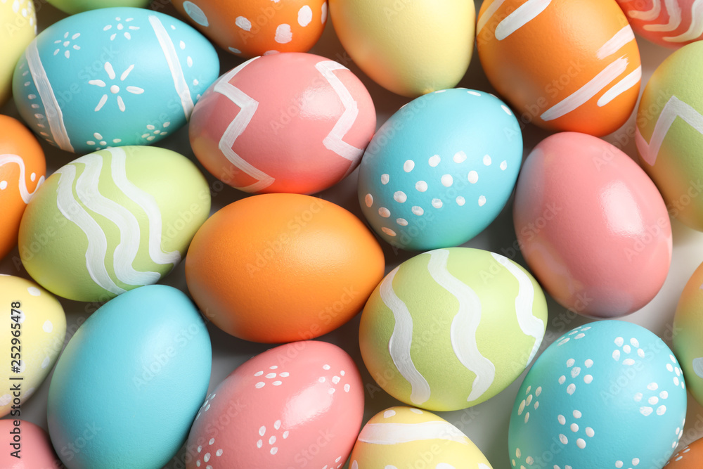 Many beautiful painted Easter eggs as background, top view