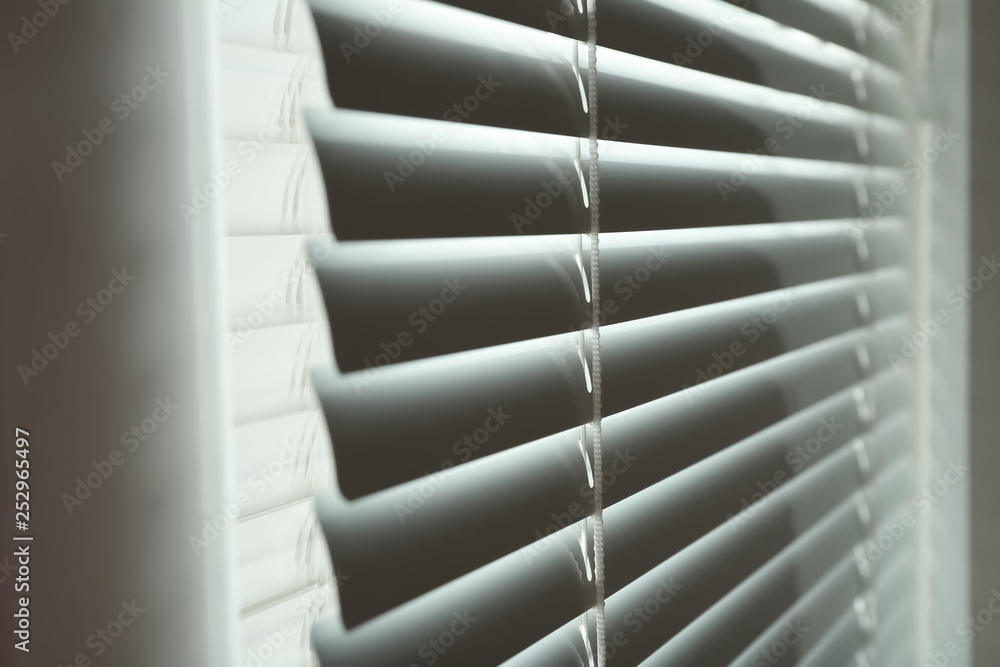 Closed modern white window blinds, closeup view Closed modern white window blinds, closeup view