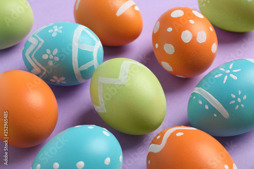 Many beautiful painted Easter eggs on color background  closeup
