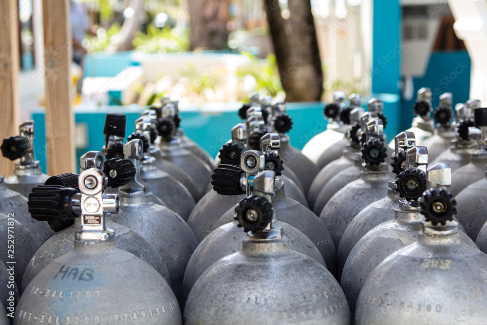 Aluminium diving tanks filled with compressed air lined up and waiting