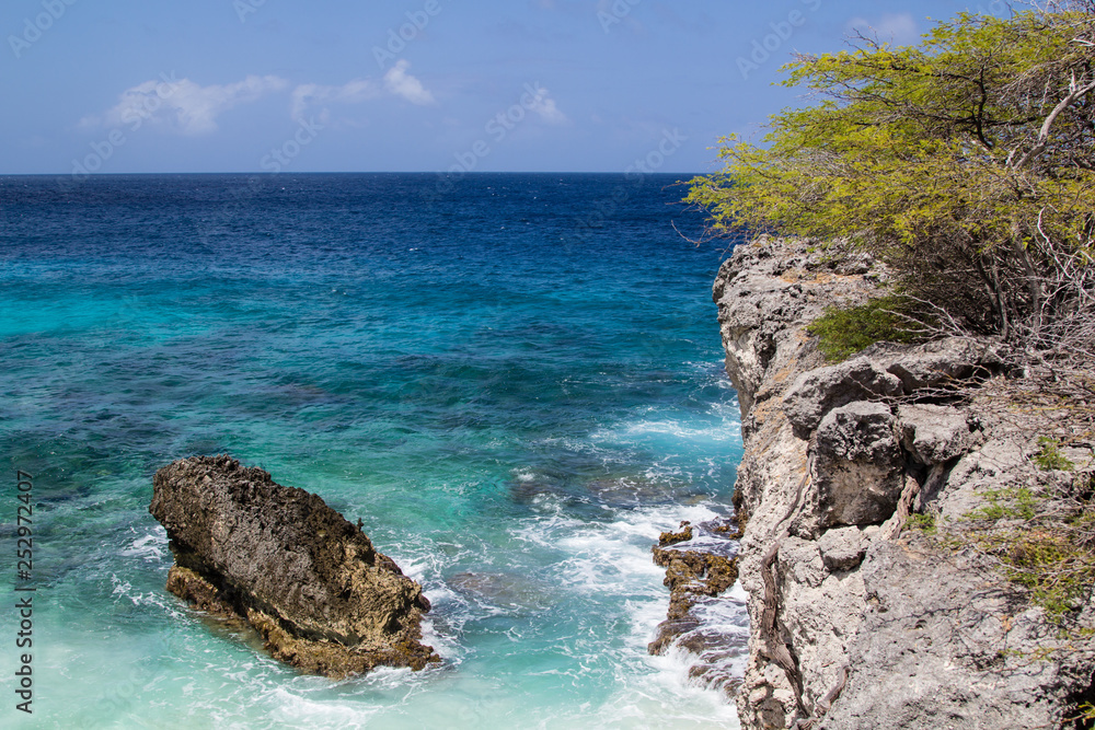 Crystal clear waters, smooth surf  and a rocky coast on ther north shore of the tropical island of Bonaire in the Netherlands Antilles